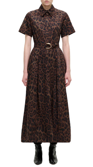 A person wears the Adam Lippes Leighton Dress in brown leopard print cotton poplin with short sleeves, collared neckline, and belted waist, paired with black ankle boots, set against a white background.