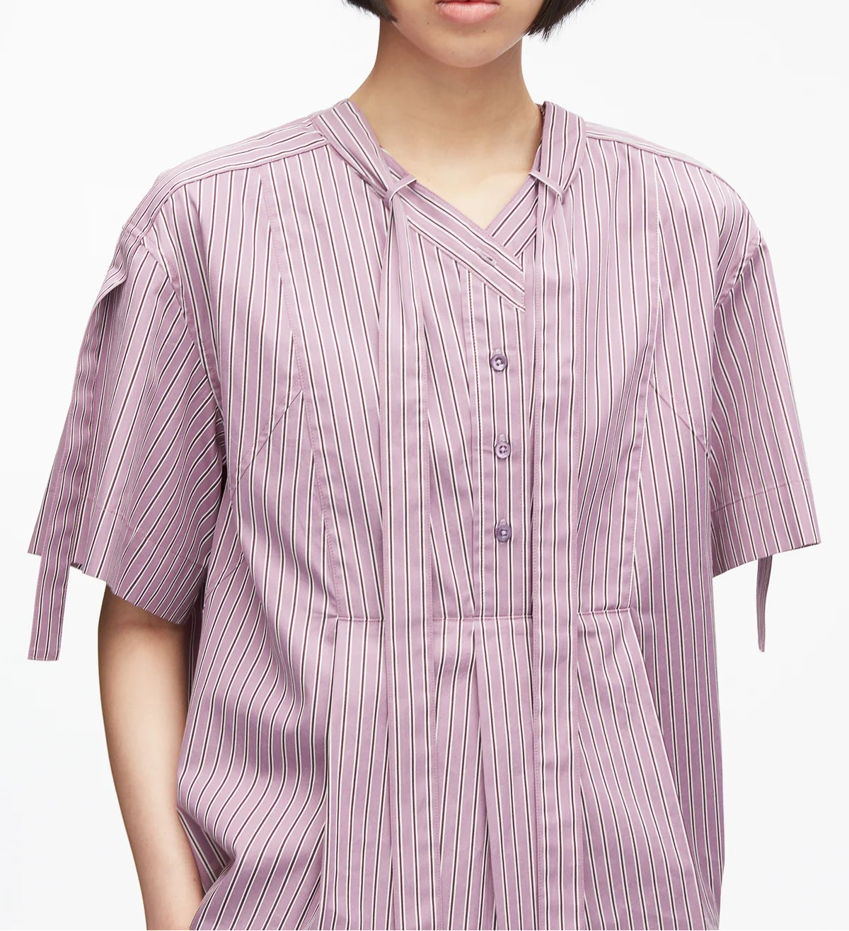 A person wearing the 3.1 Phillip Lim Short Sleeve Striped Tie Neck Blouse in light purple, featuring classic shirting details and a V-neck placket collar, shown from shoulders to mid-torso.