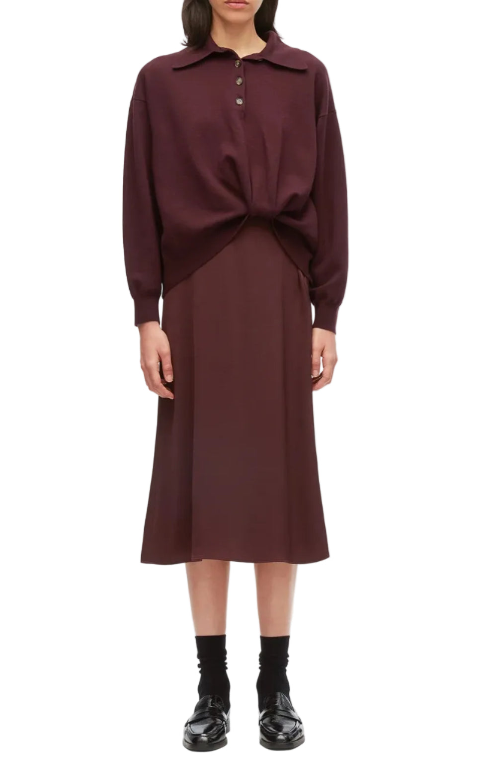 A person wearing the Ultrafine Merino Polo Midi Dress by 3.1 Phillip Lim, styled with black socks and black loafers, stands against a plain background.