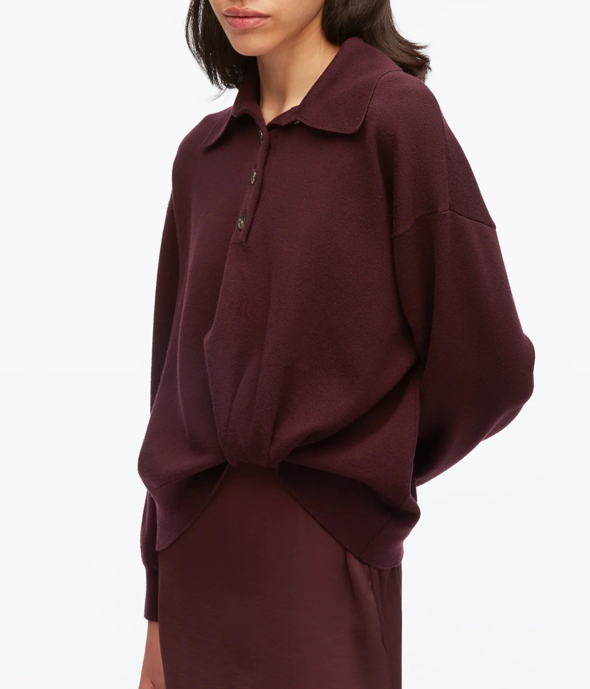 A woman wearing the 3.1 Phillip Lim Ultrafine Merino Polo Midi Dress in a loose-fitting, long-sleeve style and deep burgundy hue, standing against a plain white background.