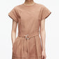A woman stands against a plain white background wearing the 3.1 Phillip Lim Pleated Poplin Tulip Sleeves Midi Dress, featuring short tulip sleeves, pintuck detailing, and a self belt at the waist in light brown cotton poplin.