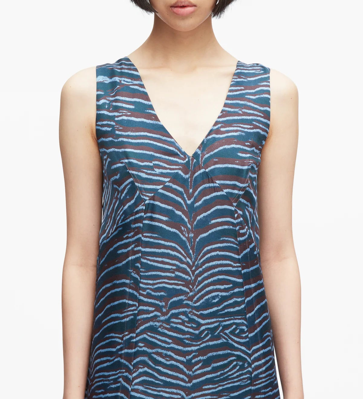 A woman models the 3.1 Phillip Lim Tiger Print Studded Midi Dress, featuring a sleeveless V-neck design with blue and brown zebra-like abstract tiger stripes, shown from shoulders to waist against a plain background.