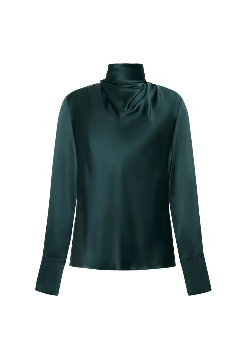 The Blaine Silk Cashmere Top by Adam Lippes features long sleeves, a loose turtleneck, and wide cuffs in dark green silk charmeuse, hand-draped against a white background.