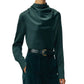 Person wearing the Blaine Silk Cashmere Top by Adam Lippes in dark green, tucked into high-waisted dark pants with a black belt, face partially out of frame.