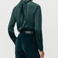 Person wearing the Adam Lippes Blaine Silk Cashmere Top in hunter green with tied neck detail and matching velvet pants, seen from the back.