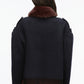 Person with long brown hair wearing the 3.1 Phillip Lim Wool Blanket Zip Up Jacket—an artisanal outerwear piece featuring a dark hue, faux fur collar, and fringe hem—photographed from behind against a plain background.