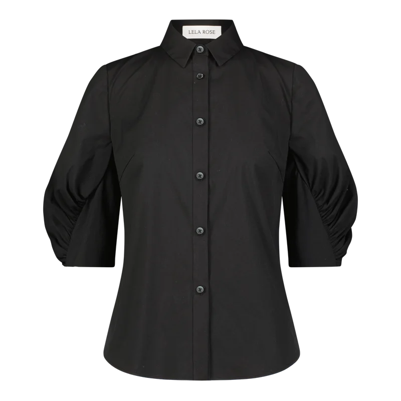 The Lela Rose Cotton Poplin Shirred Sleeve Shirt is a black button-up cotton poplin shirt with a collar and shirred, puffed three-quarter sleeves. It features a relaxed silhouette and is displayed against a plain white background.