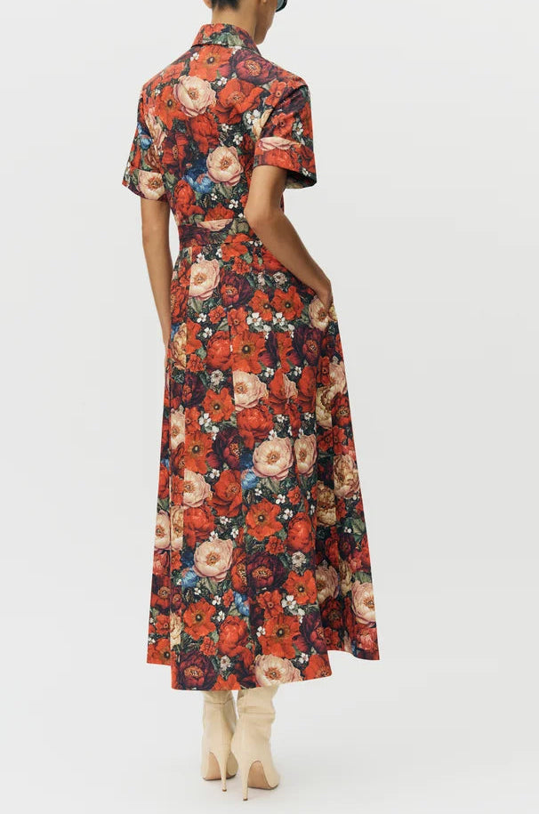 Person shown from the back wearing the Leighton Dress by Adam Lippes in vibrant floral Italian cotton poplin, paired with cream heeled boots.
