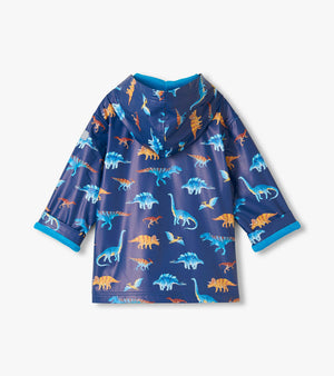 The Hatley Boys’ Colourful Dinos Rain Coat features a blue background with vibrant dinosaur prints, shown from the back with a hood and rolled cuffs.
