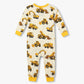 Hatley’s Baby Boys’ Construction Trucks Bamboo Overall features long sleeves, yellow cuffs, and a cream background adorned with an all-over print of yellow and brown construction trucks.