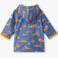 Hatley’s Baby Boys’ and Boys’ Construction Trucks Rain Coat is a vibrant blue hooded rain jacket for kids, decorated with bright yellow prints of dump trucks, excavators, and cement mixers. Shown laid flat with the sleeves and hood visible, this waterproof jacket is perfect for keeping little ones dry on rainy days.
