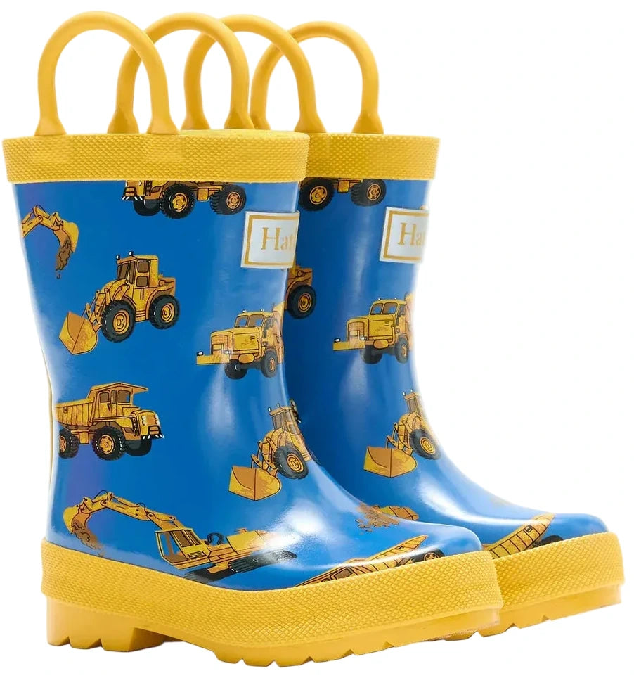 Hatley Construction Trucks Rain Boots with Handles are children’s waterproof boots designed with a playful blue and yellow construction vehicle pattern on the sides and convenient handles for easy pulling on. These boots are perfect for kids to splash in puddles on rainy days.