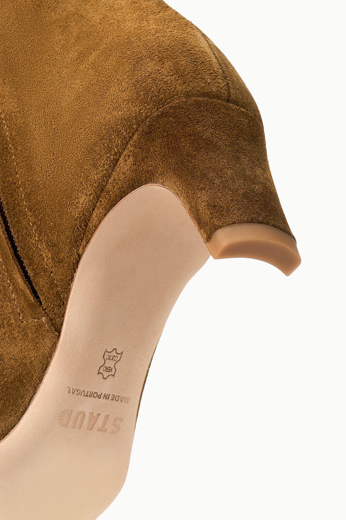 Close-up of the heel and sole of a brown Staud Wally Suede Ankle Boot, with “STAND” and “MADE IN PORTUGAL” stamped on the light-colored sole—emphasizing the everyday versatility of this boot.