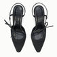 A pair of Staud Inez Heel black pointed-toe slingback shoes featuring thin elastic back straps and side bow detailing, viewed from above on a white background. This stylish design adds a chic touch to your ensemble, capturing the timeless elegance of the Inez Heel by Staud.