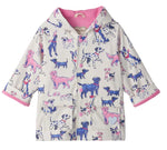 The Hatley Baby Girls’ and Girls’ Little Pups Rain Coat features a charming print of blue, pink, and purple cartoon dogs on a white background, a soft terry towelling lining, and two front pockets.