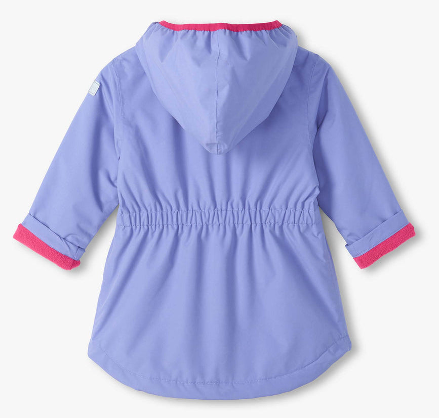The Girls’ Pretty Bows Reveal Field Jacket by Hatley is shown from the back against a white background. This light purple periwinkle hooded jacket for girls features pink trim on the cuffs, an elastic waistband, a curved hem, and charming details that add both playful style and comfort.