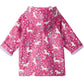 The Hatley Baby Girls’ and Girls’ Unicorn Forest Rain Coat is a pink rain jacket for children, featuring a hood and decorated with white unicorns and a floral pattern; the rolled-up sleeves reveal a light purple lining.