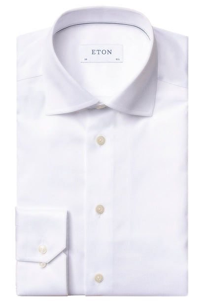 Folded Eton White Signature Twill Shirt, Slim Fit with buttoned cuffs, crafted from Signature Twill fabric, featuring a label inside the collar that reads "ETON". This versatile business shirt is designed to be wrinkle-free, ensuring you stay sharp all day.