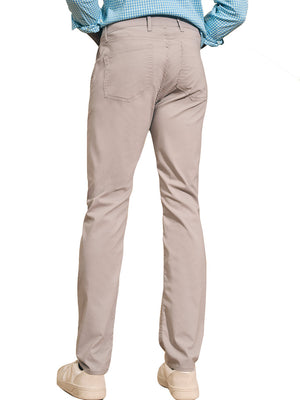 A person wearing Faherty's Movement Five Pocket Pant and a blue checkered shirt stands with their back to the camera, highlighting beige casual shoes. The pants' 4-way stretch fabric ensures comfort in every step, ideal for those on the move.