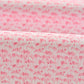 Close-up of the Johnnie-O Flock Yeah Performance Mesh Polo's pink fabric, featuring small abstract animal shapes in a darker pink shade.