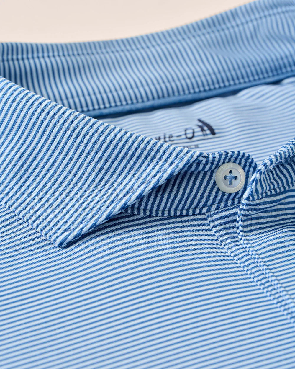 Close-up of the Johnnie-O Waverunner Polo, a men's blue and white striped collared shirt with buttons, highlighting the fabric's texture and pattern—this stretch polo offers UPF 50 protection and moisture-wicking properties for all-day comfort.