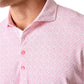 Close-up of a person wearing the Johnnie-O Flock Yeah Performance Mesh Polo, featuring a pink and white collared design with a small repeating pattern and three pink buttons—ideal for stylish golf attire.
