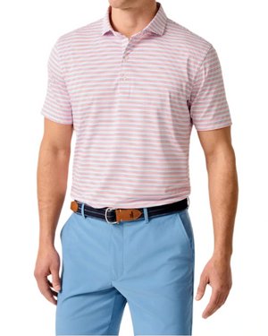 A man stands against a white background wearing the Kamdon Performance Jersey Polo by Johnnie-O—a lightweight, light pink and white striped short-sleeve shirt with UPF 50 protection—paired with light blue pants and a dark belt.