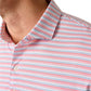 Close-up of a person wearing the Johnnie-O Kamdon Performance Jersey Polo, featuring horizontal red, white, and blue stripes with two visible white buttons. Its moisture-wicking fabric ensures cool, comfortable wear.