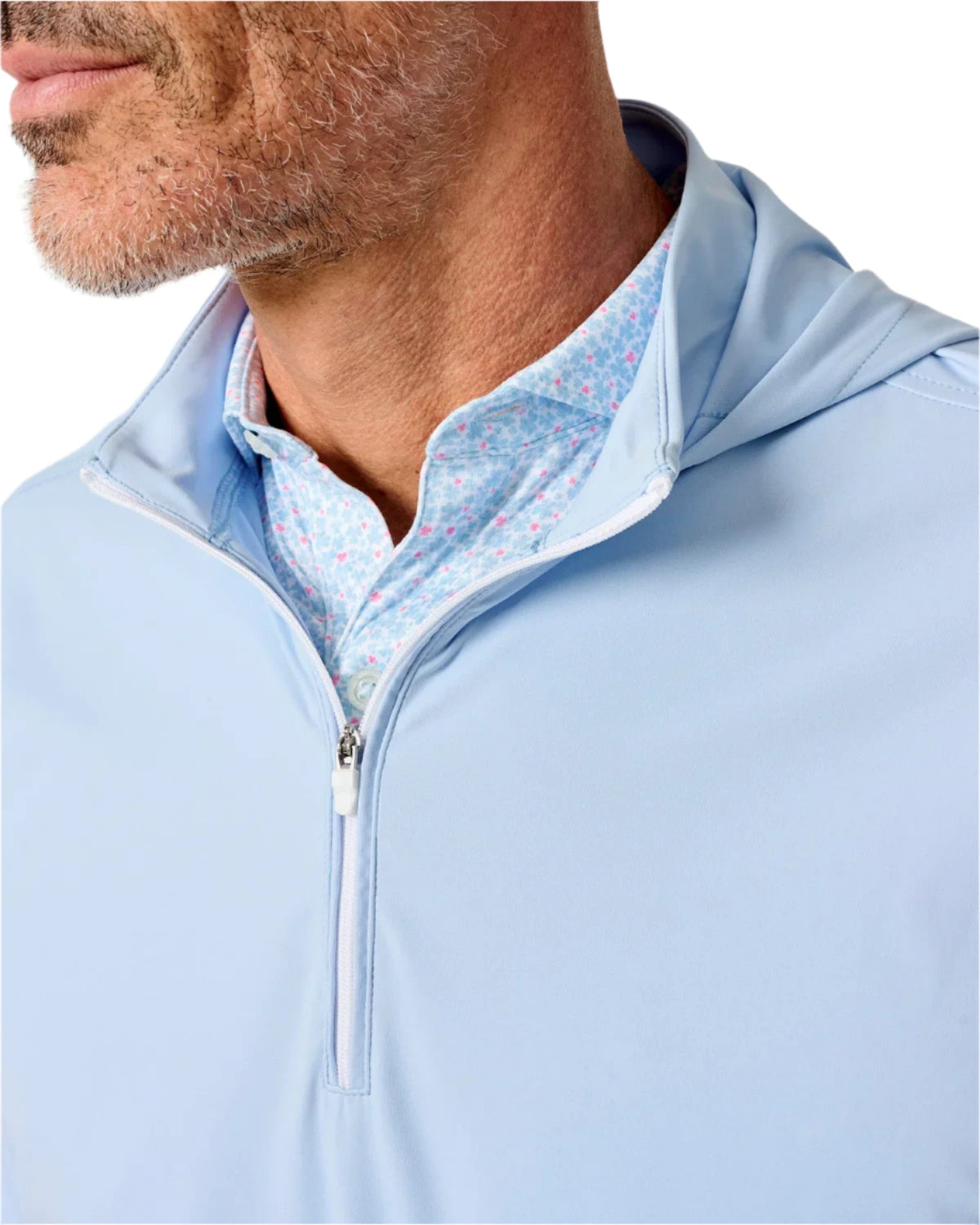 A man wears the Johnnie-O Robby Performance 1/4-Zip Hybrid Hoodie in light blue over a blue patterned collared shirt—crafted from a nylon blend, ideal for all-day comfort.