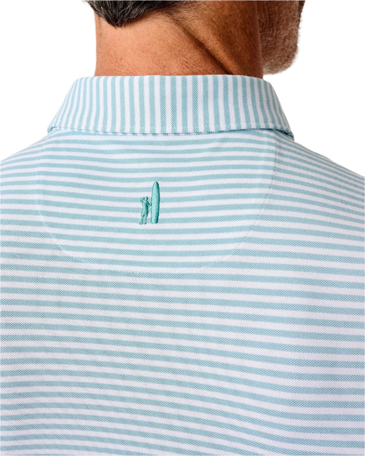 Close-up of the back of a person's neck and shoulders wearing the Johnnie-O Stetson Stripe Performance Mesh Polo in light blue and white stripes, featuring a small embroidered surfer and surfboard.