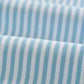 Close-up of light blue and white vertical stripes on the textured fabric of the Johnnie-O Stetson Stripe Performance Mesh Polo, shown in folds.