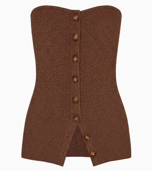 Ulla Johnson’s Yanni Strapless Knit Top is a brown ribbed knit tube top featuring a corset-inspired front with eight button closures and a small slit at the hem—the perfect statement piece.