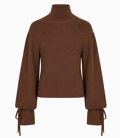 The Ulla Johnson Camille Knit Pullover is a brown ribbed knit sweater featuring a high neck, elongated wide long sleeves, and tied cuffs, shown against a plain white background.