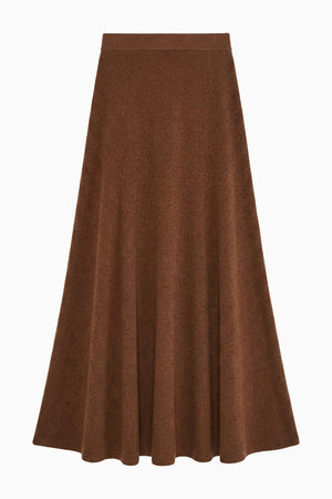 A brown, knee-length Azaria Knit Skirt by Ulla Johnson featuring an A-line silhouette with soft panels and a fitted waistband, crafted from luxurious merino wool and displayed against a white background.
