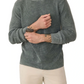 A person wearing the Faherty Sunwashed Crewneck Sweater in a textured waffle stitch with gray and light beige pants, showing visible forearm tattoos, stands against a white background.