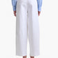 Person wearing the Altuzarra Dash Pant in white, paired with a light blue embroidered blouse and beige loafers, shown from the back against a plain background.