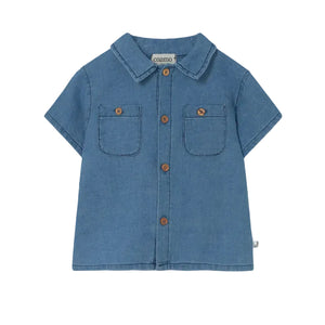 The Cozmo Baby Boys' Forest Chambray Shirt features blue denim, short sleeves, two chest pockets, brown buttons, and a collar, shown on a white background.