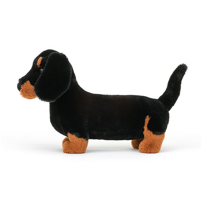 Freddie Sausage Dog, a black and brown dachshund stuffed animal by Jellycat.