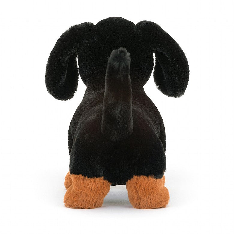 Freddie Sausage Dog, a black and brown dachshund stuffed animal by Jellycat.