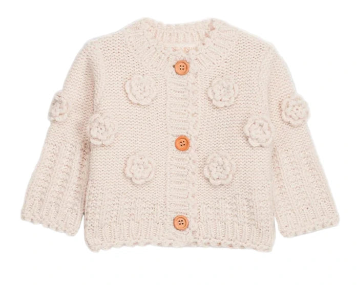 The Louise Misha Baby Girls' and Girls' Sandy Cardigan is a cream knit with long sleeves, button front, and hand-crocheted flower appliqués on the front and sleeves.