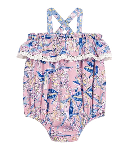 The Kumal Romper by Louise Misha features a pink floral print with a ruffled, lace-trimmed top and blue crisscross shoulder straps, crafted from soft cotton veil and shown against a white background.