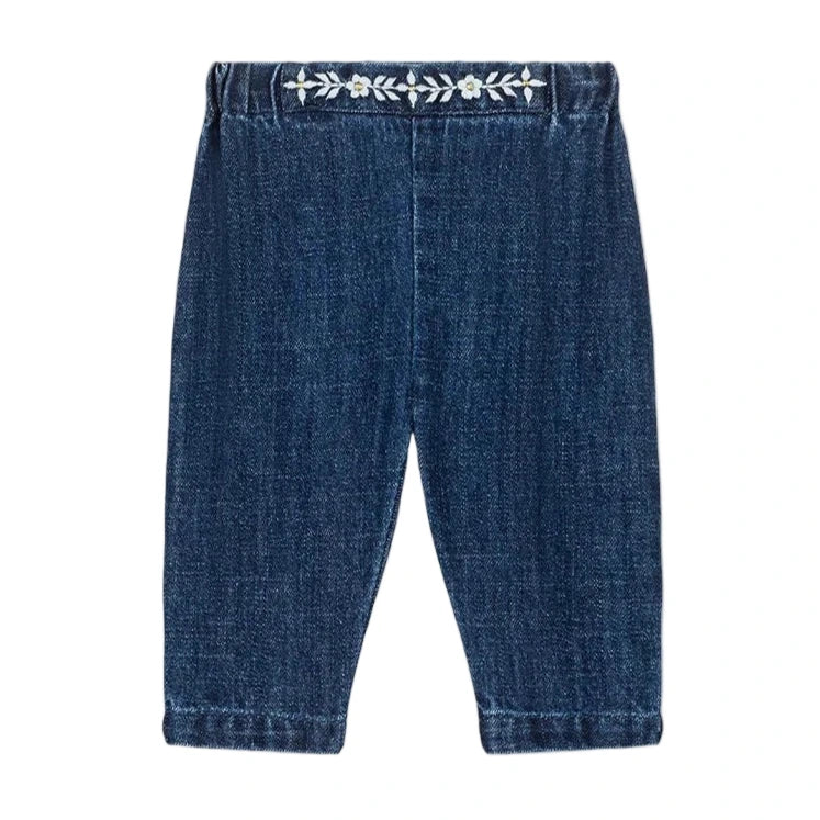 Louise Misha Baby Girls' Flofia Pants in dark blue denim with an elastic waistband and delicate white embroidery along the top, shown flat on a white background.
