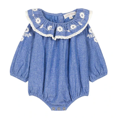 The Louise Misha Baby Girls' Ilani Romper features long sleeves, white floral embroidery, lace-trimmed ruffled collar, elastic cuffs, and convenient snap buttons at the bottom.