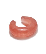 The Arc Marbled Cuff by Lizzie Fortunato features a smooth, polished pink marbled resin and an open-ended domed design—an eye-catching statement piece shown on a white background.