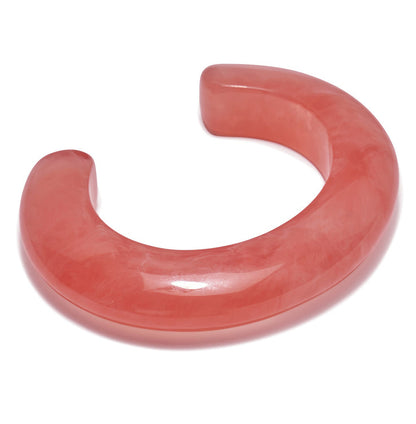 The Ridge Marbled Cuff by Lizzie Fortunato is a chunky, translucent pink resin bracelet with a smooth, glossy finish and open-ended crescent shape—a striking statement piece for modern jewelry lovers.