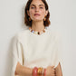 Woman in a white top wears colorful chunky jewelry—highlighted by the Lizzie Fortunato Ridge Marbled Cuff—alongside a pink resin beaded necklace, matching earrings, and several large bangles that pop against the plain backdrop.