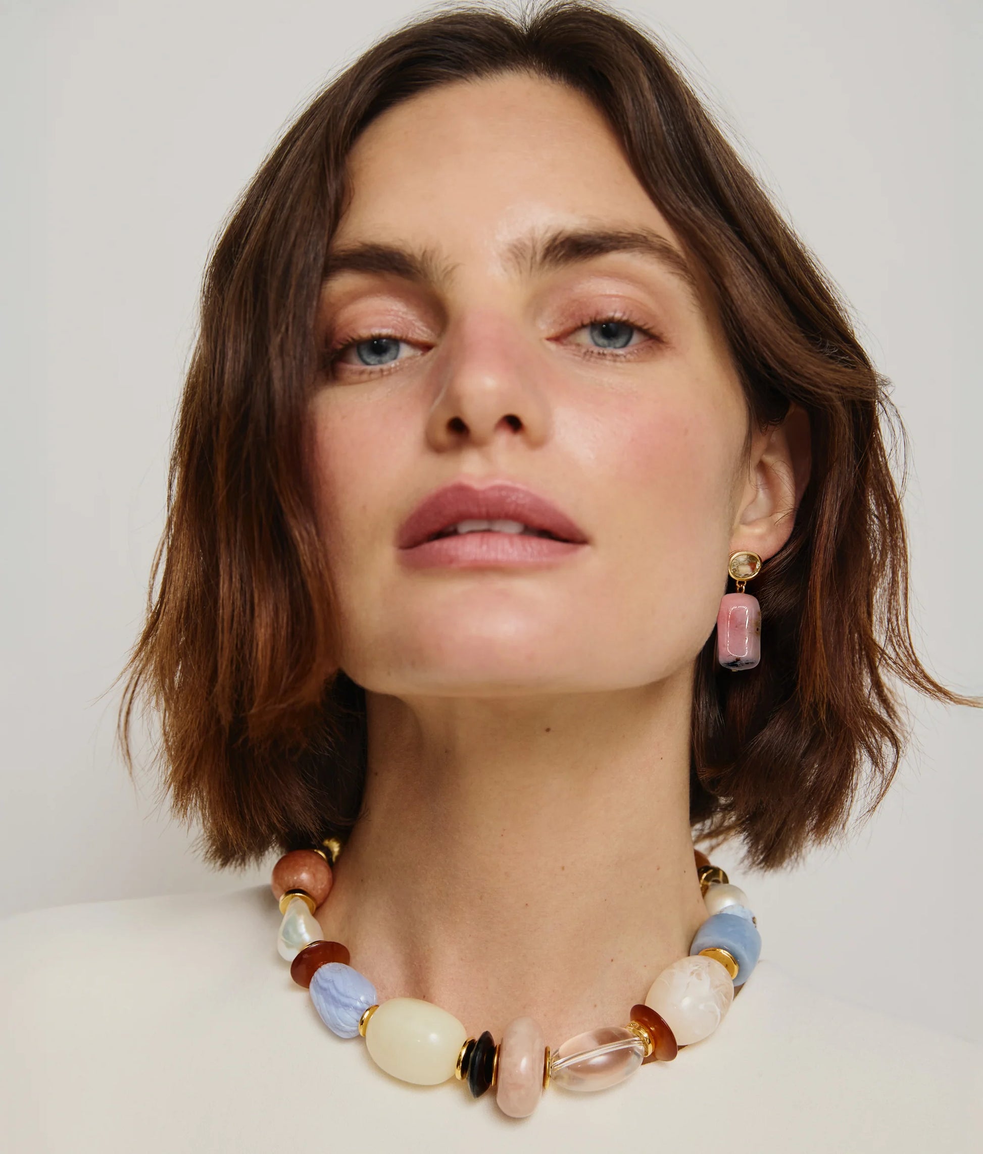 A woman with short brown hair wears the Lizzie Fortunato Monument Collar and matching rectangular earrings, looking directly at the camera.