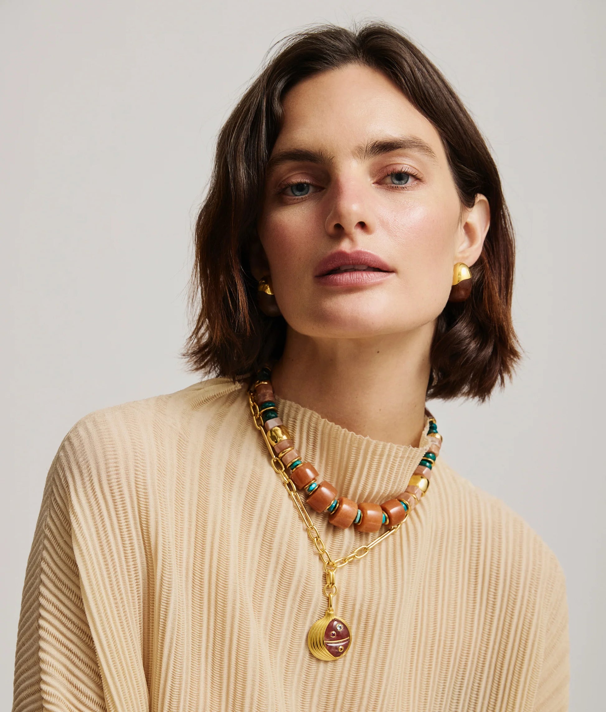 Woman with short brown hair wears a beige ribbed top, gold earrings, and the Lizzie Fortunato Granada Necklace, looking directly at the camera.