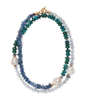 The Cabana Necklace by Lizzie Fortunato is a double-stranded piece with blue, green, and white beads, two large irregular pearls, and a gold clasp.