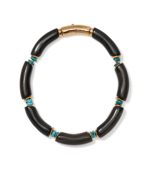 The Cathedral Collar by Lizzie Fortunato is a black horn beads necklace with curved segments, small turquoise stones, gold accents, and a gold clasp.